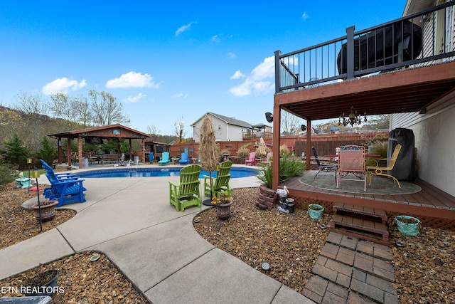 view of pool featuring a gazebo, a wooden deck, and a patio area