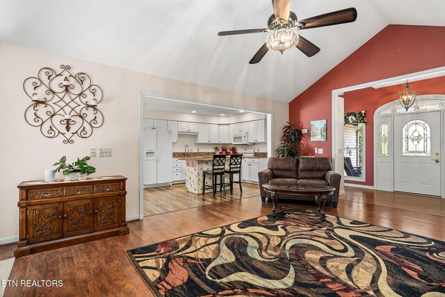 living room featuring dark hardwood / wood-style flooring, ceiling fan, and lofted ceiling