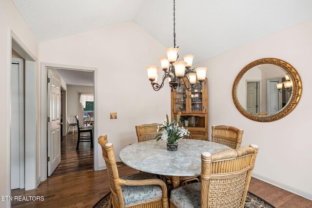 dining area featuring dark hardwood / wood-style flooring, a chandelier, and lofted ceiling