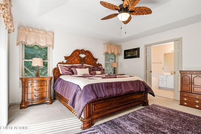 carpeted bedroom featuring ceiling fan and ensuite bath