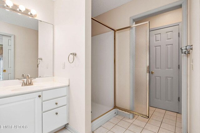 bathroom featuring tile patterned flooring, vanity, and walk in shower