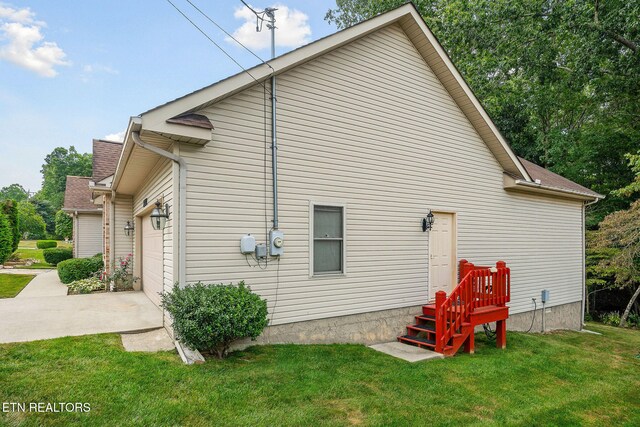 view of home's exterior with a garage and a lawn