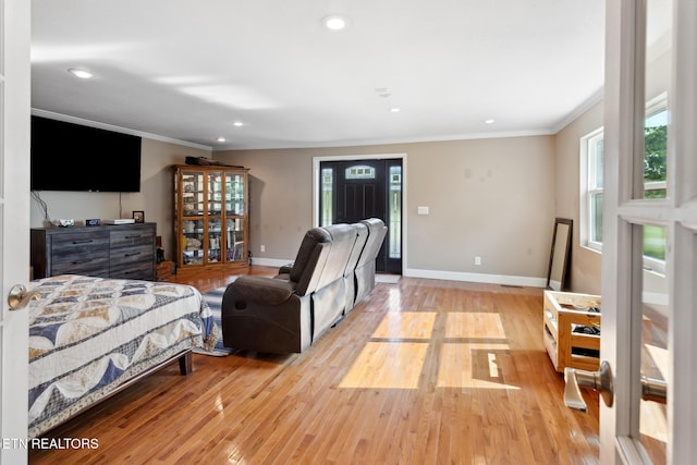 bedroom with multiple windows, light hardwood / wood-style floors, and ornamental molding