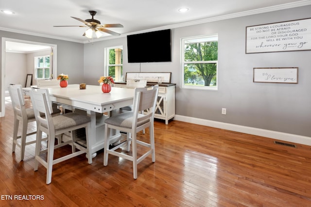 dining area featuring ceiling fan, hardwood / wood-style floors, a healthy amount of sunlight, and ornamental molding