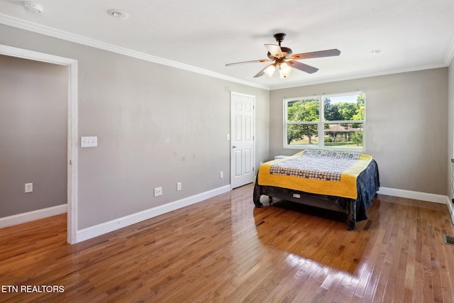 bedroom with wood-type flooring, ceiling fan, and ornamental molding