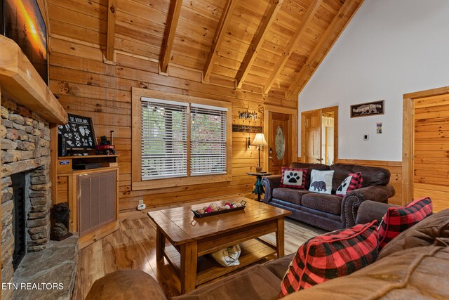 living room with wooden walls, high vaulted ceiling, wooden ceiling, a fireplace, and light hardwood / wood-style floors