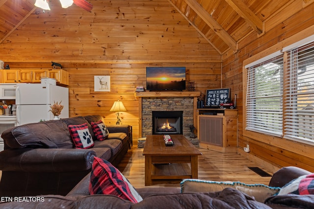 living room featuring wooden walls, a fireplace, wood ceiling, and light hardwood / wood-style floors