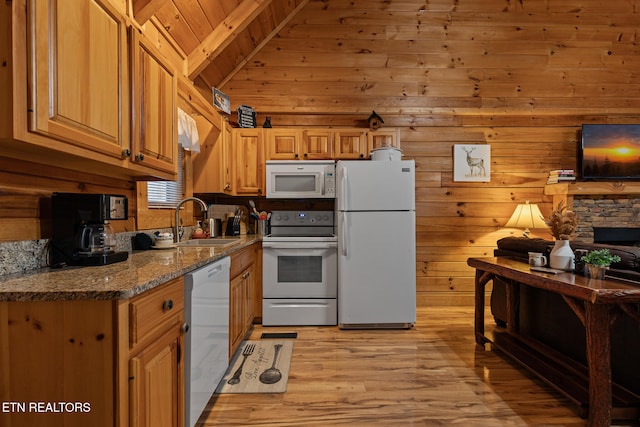 kitchen with white appliances, sink, wooden walls, light wood-type flooring, and stone countertops