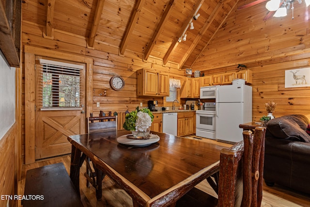 dining area featuring beam ceiling, wooden ceiling, high vaulted ceiling, light hardwood / wood-style floors, and wooden walls