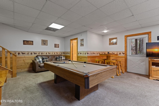 playroom with light carpet, a paneled ceiling, wooden walls, and pool table