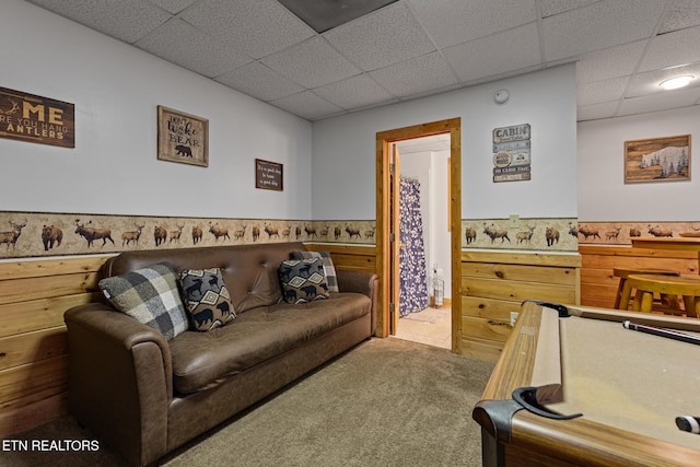 living room with a drop ceiling and carpet floors