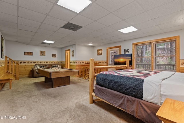 bedroom with carpet floors, pool table, a drop ceiling, and wood walls