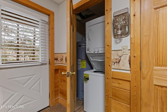 washroom featuring stacked washer and dryer and water heater