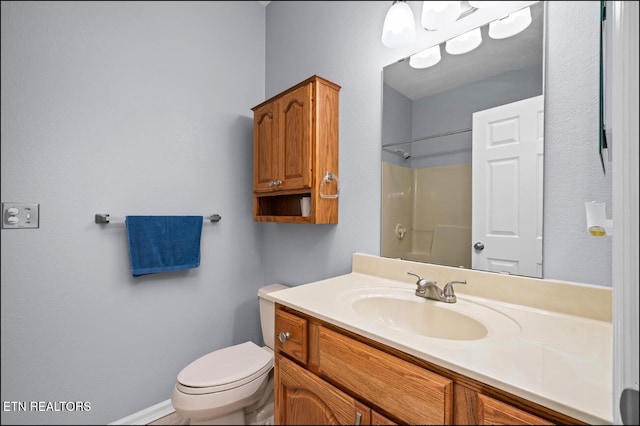 bathroom with vanity, toilet, and a shower