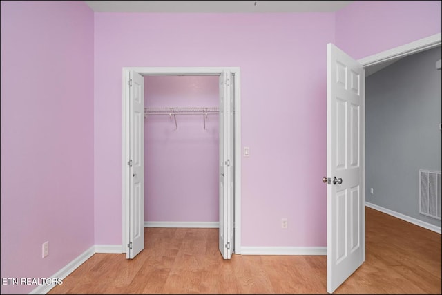 unfurnished bedroom featuring a closet and light hardwood / wood-style floors