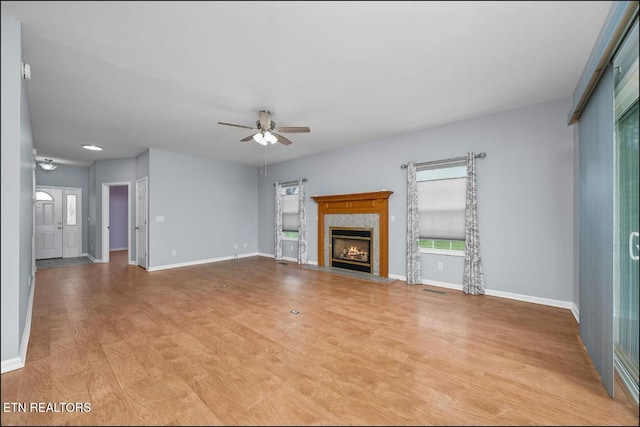 unfurnished living room featuring light hardwood / wood-style flooring, ceiling fan, and a healthy amount of sunlight