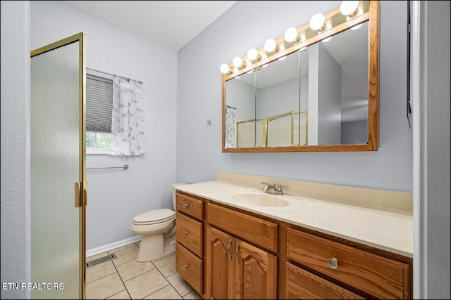 bathroom featuring a shower, vanity, tile patterned floors, and toilet