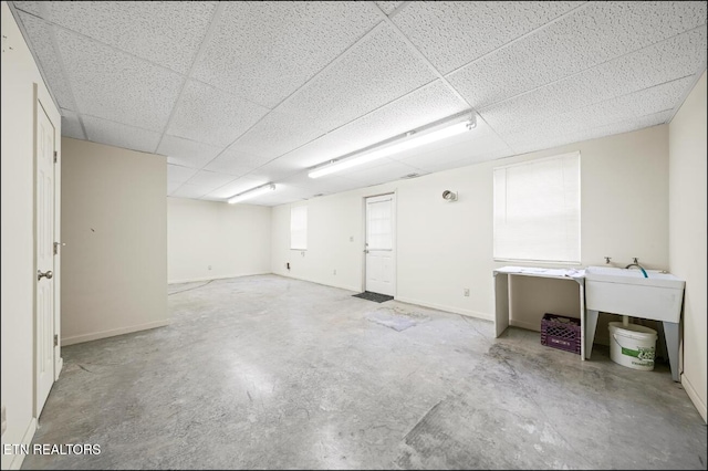 basement with a paneled ceiling