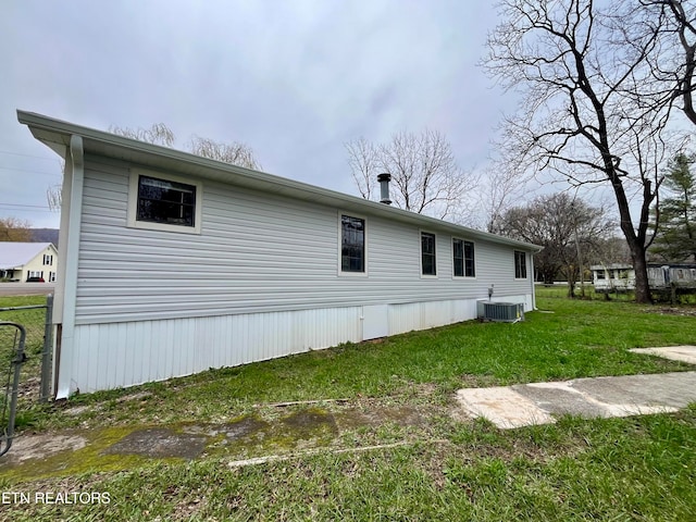 view of home's exterior with central air condition unit and a yard