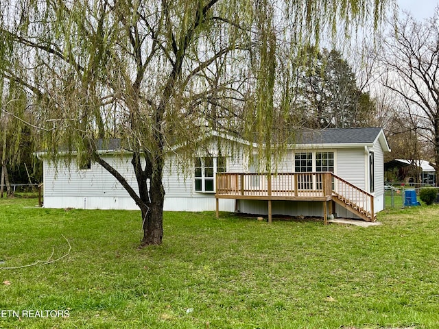 back of property featuring a yard and a deck