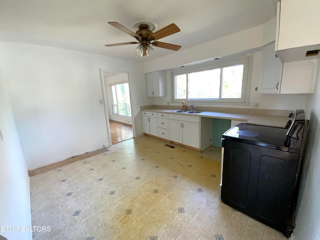 kitchen featuring range with electric cooktop, sink, white cabinets, and ceiling fan