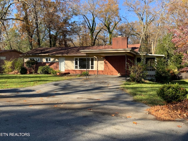 single story home featuring a front lawn and a carport