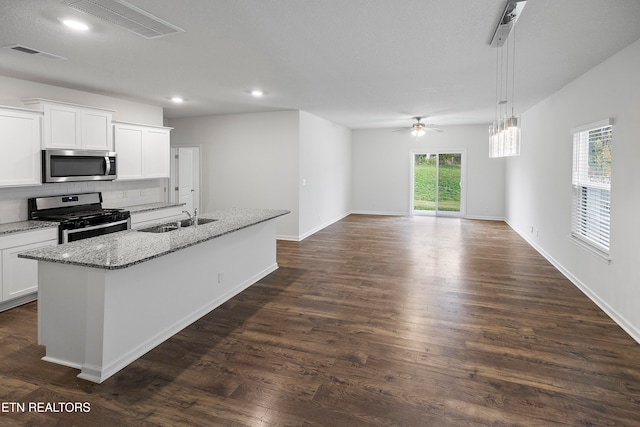 kitchen featuring sink, dark hardwood / wood-style floors, an island with sink, white cabinetry, and stainless steel appliances