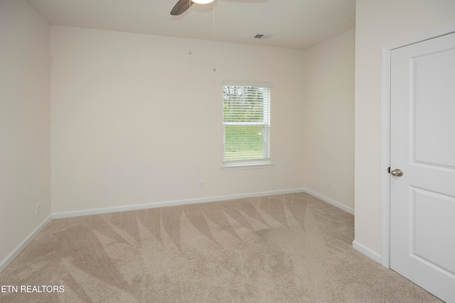 carpeted spare room with ceiling fan