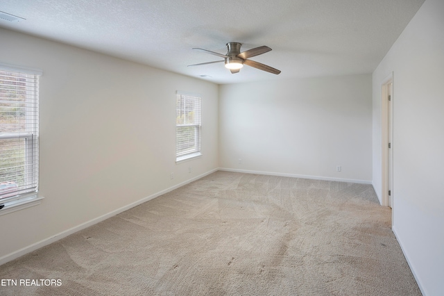 carpeted spare room with ceiling fan and a textured ceiling