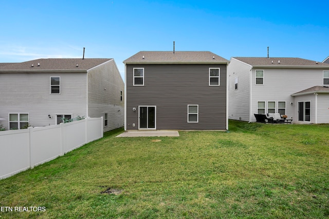 rear view of house with a yard and a patio