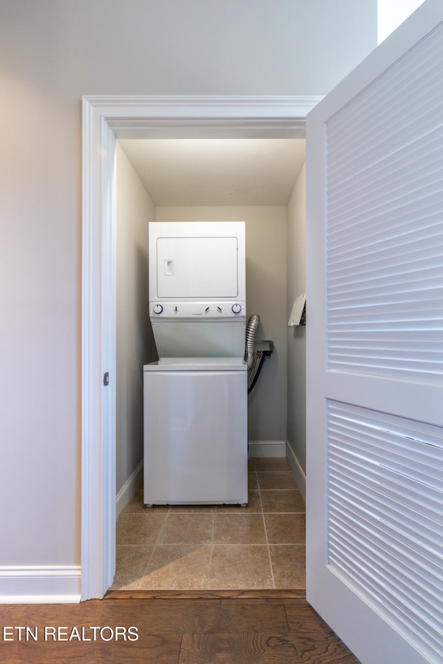 laundry area featuring hardwood / wood-style floors and stacked washer and dryer