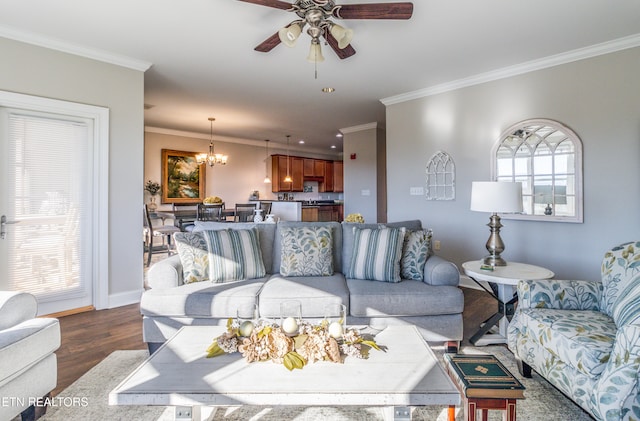 living room featuring ceiling fan with notable chandelier, ornamental molding, dark wood-type flooring, and a wealth of natural light