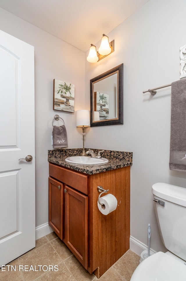 bathroom featuring tile patterned floors, vanity, and toilet