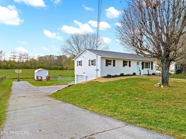 view of front of house featuring a storage unit, a garage, and a front lawn