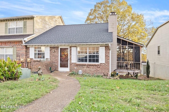 view of front of property featuring a sunroom and a front yard