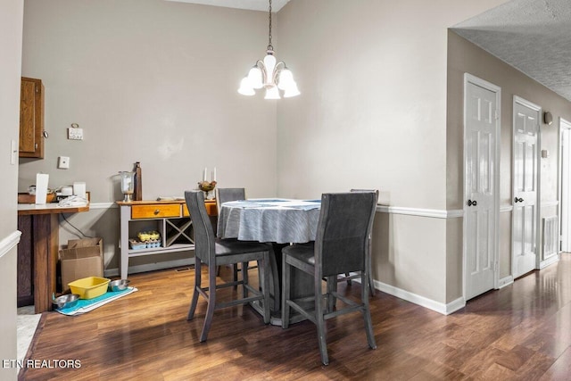 dining area featuring hardwood / wood-style floors and an inviting chandelier