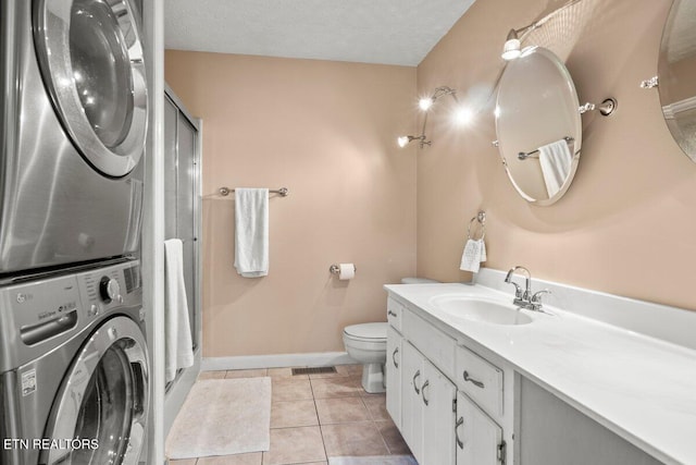 bathroom with tile patterned flooring, a textured ceiling, walk in shower, and stacked washer / drying machine