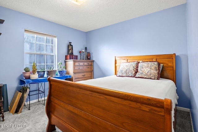 bedroom with light colored carpet and a textured ceiling