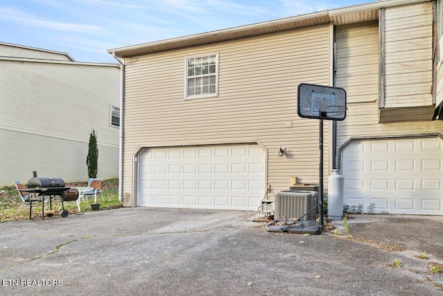 view of side of property featuring a garage and central AC unit