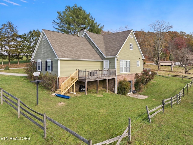 rear view of house featuring a wooden deck and a yard