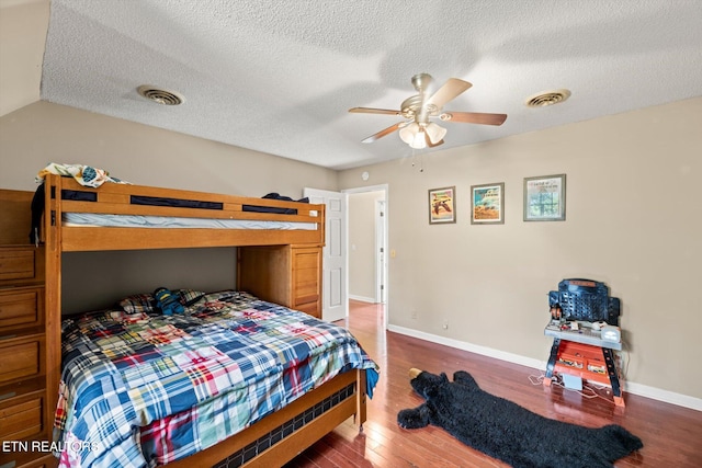 bedroom with wood-type flooring, a textured ceiling, ceiling fan, and lofted ceiling