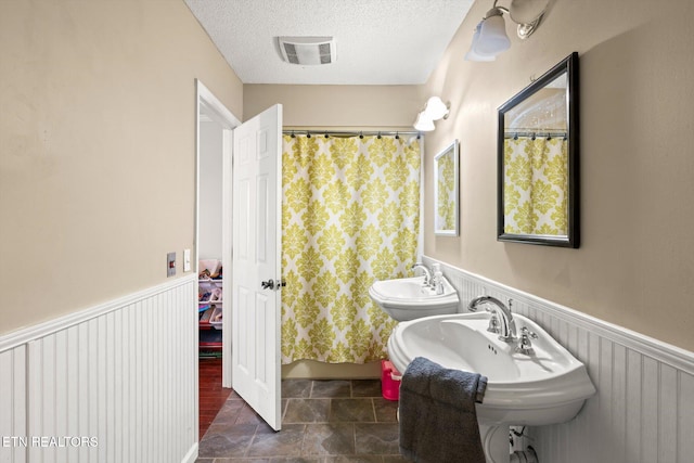 bathroom with a textured ceiling and walk in shower