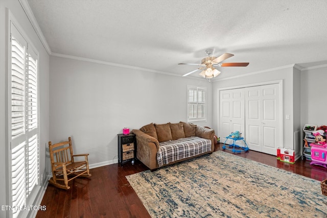 living room with crown molding, ceiling fan, dark hardwood / wood-style flooring, and a textured ceiling