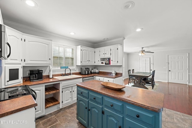 kitchen with blue cabinetry, white cabinetry, ceiling fan, and sink