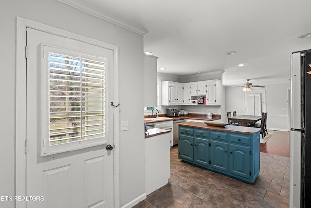 kitchen featuring white cabinets, butcher block countertops, a wealth of natural light, and white fridge