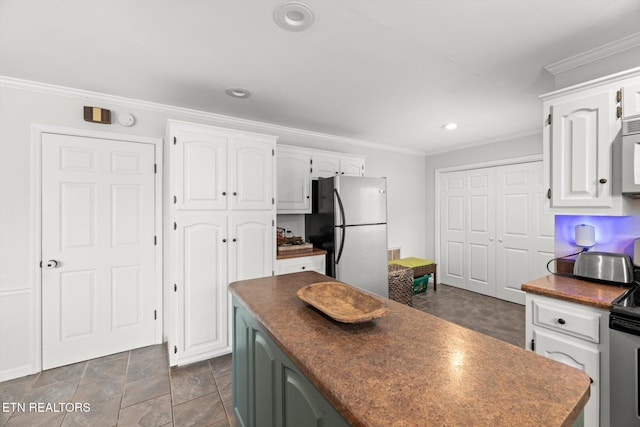 kitchen with stainless steel appliances, white cabinetry, and crown molding