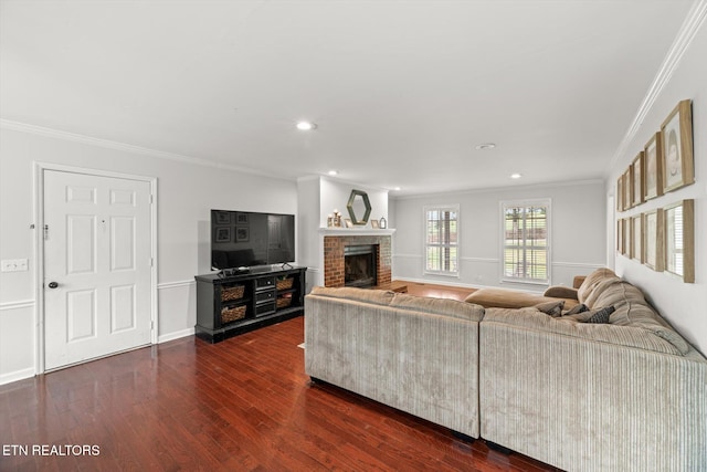 living room with ornamental molding, dark wood-type flooring, and a brick fireplace