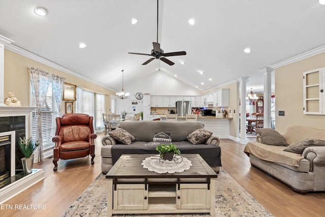 living room with light wood-type flooring, ornamental molding, a tiled fireplace, and vaulted ceiling