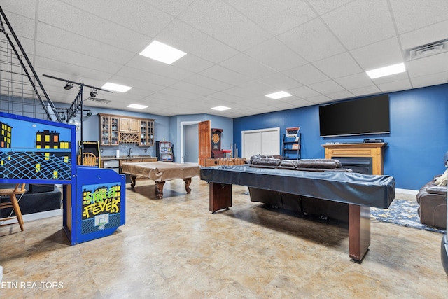 recreation room with concrete flooring, a paneled ceiling, sink, and pool table