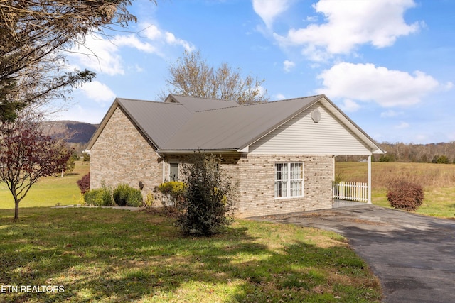 view of side of home with a yard and a carport